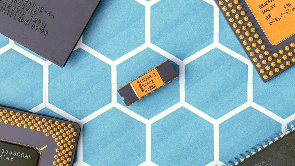 Close-up of various microprocessor chips on a blue hexagonal patterned surface, highlighting electronic technology.